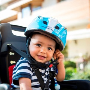 Glückliches Baby mit Sicherheitsgurt und Helm im Babyhotel Tyrol, Naturns