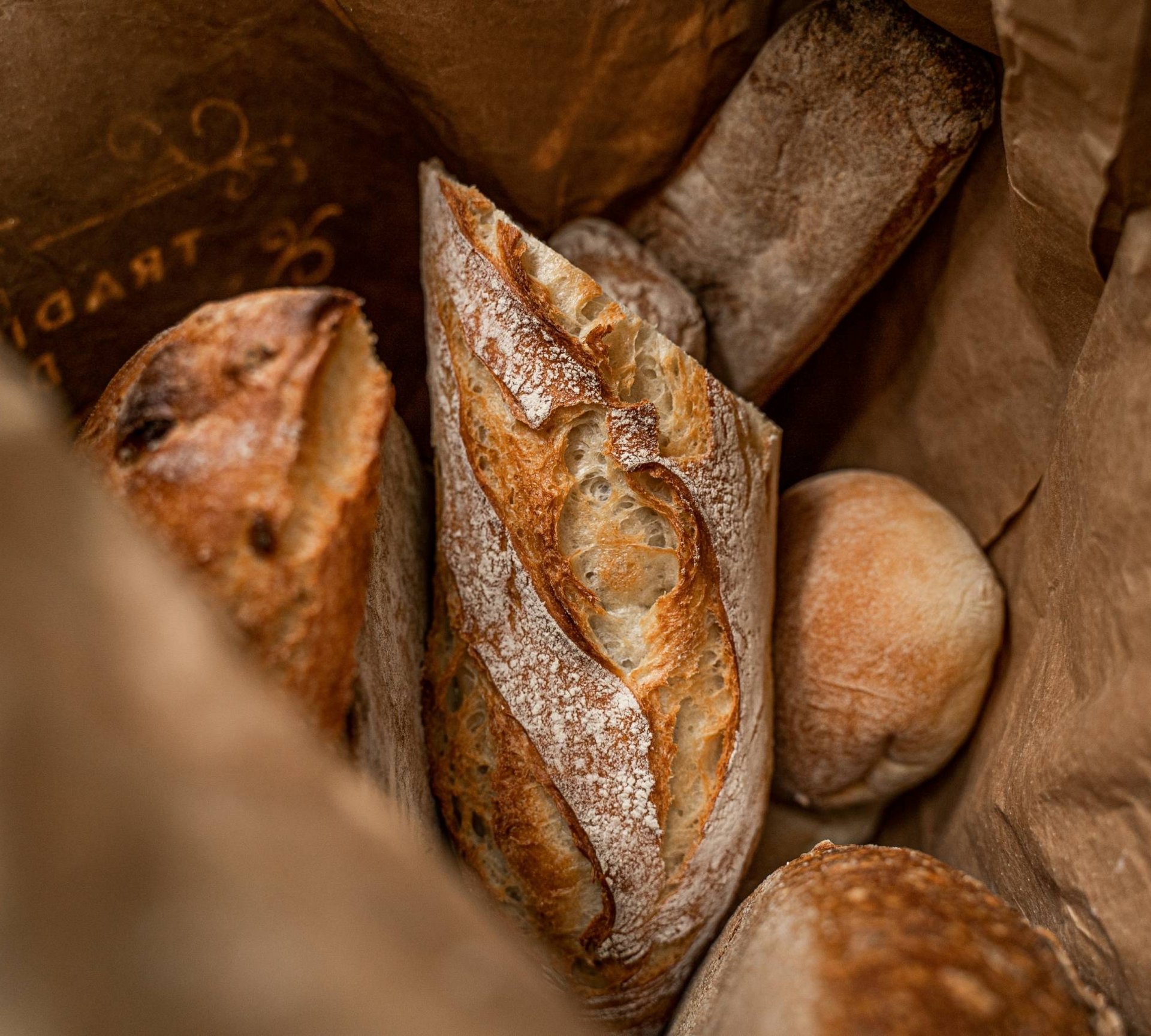 Assorted breads in a brown paper bag