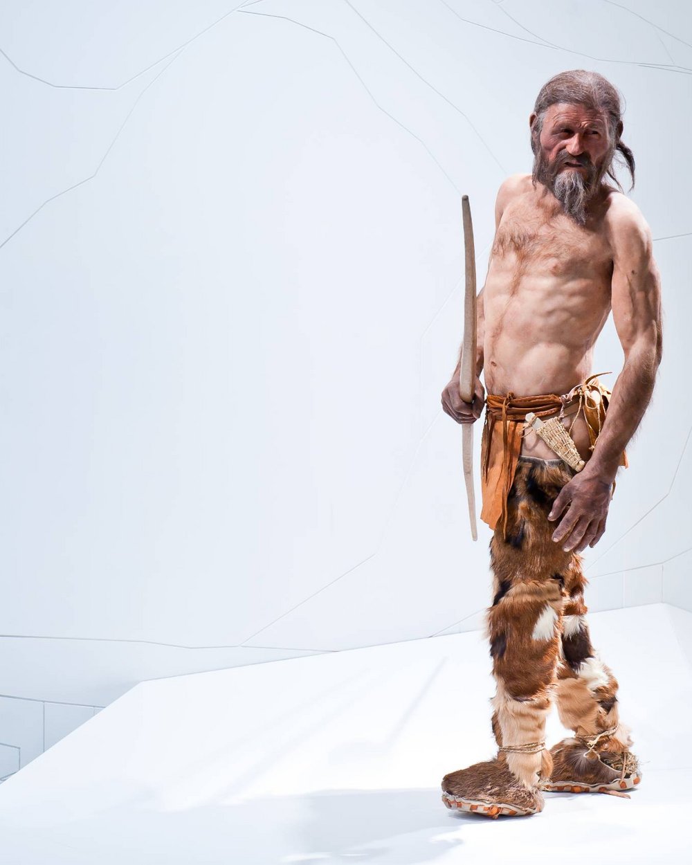 Rekonstruktion des prähistorischen Mannes Ötzi mit Fellkleidung und Bogen