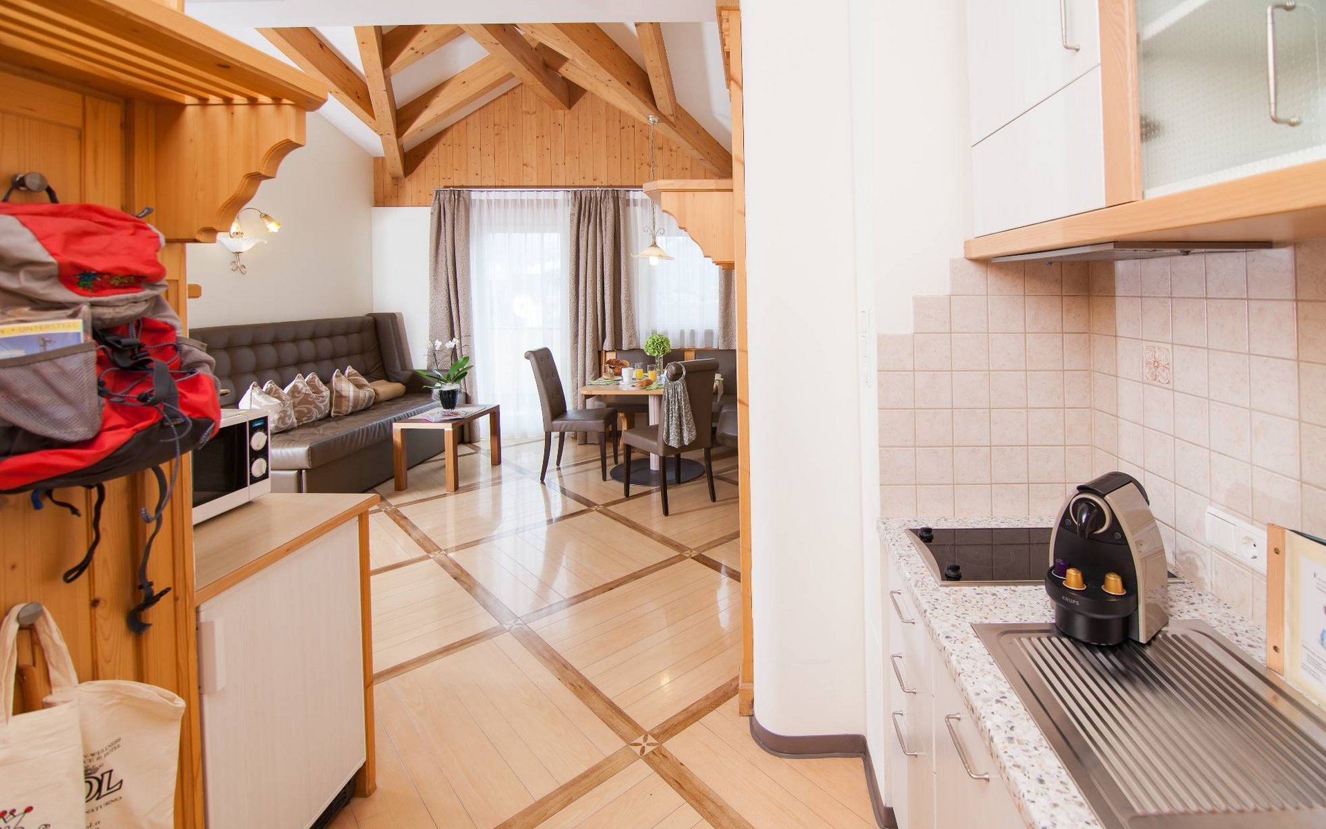 Gemütliche Wohnküche mit Holzbalken, Esstisch und Kaffeemaschine