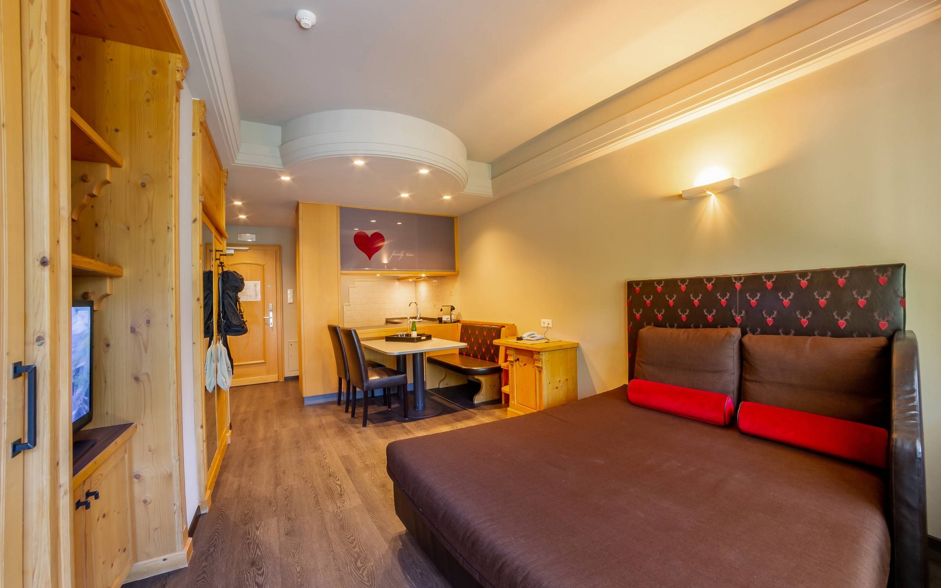 Gemütliches Hotelzimmer mit Doppelbett, Esstisch und Küchenzeile