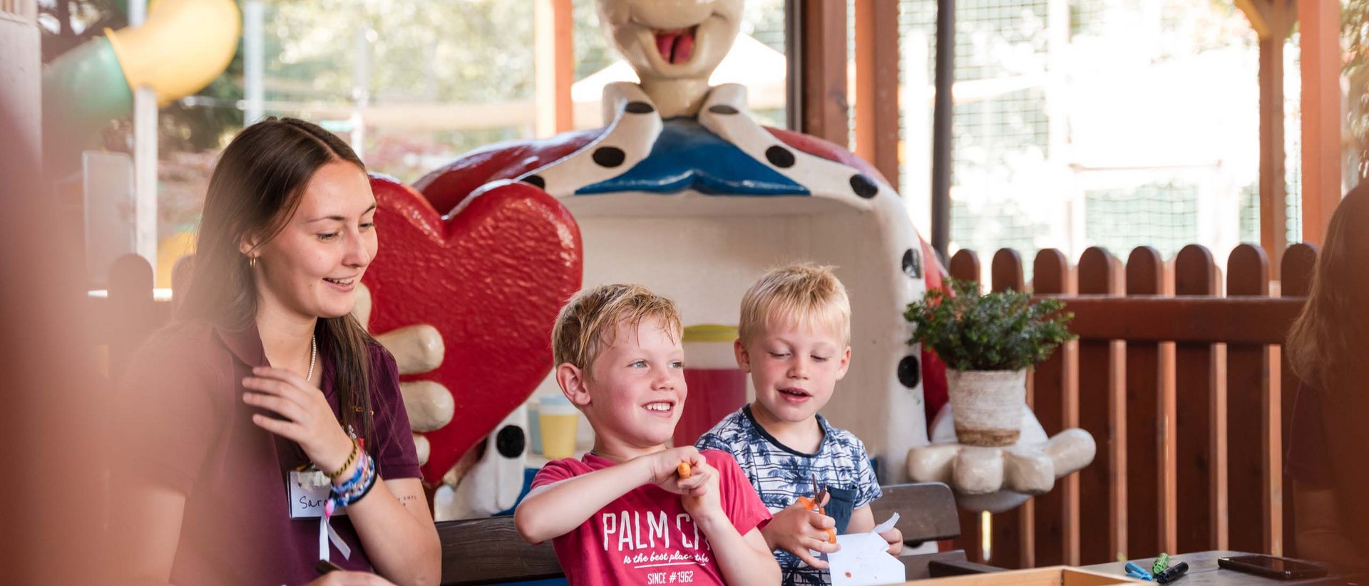 TYROL Family Retreat: eines der besten Kinderhotels Europas Kinder basteln unter Anleitung neben einer großen Herzfigur im Freien