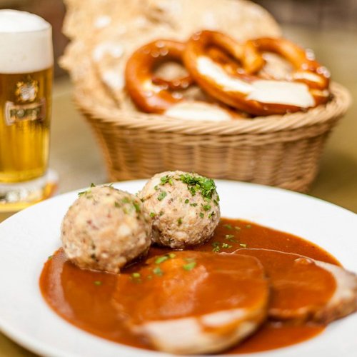 Bavarian meal with dumplings, roast pork, pretzels, and beer