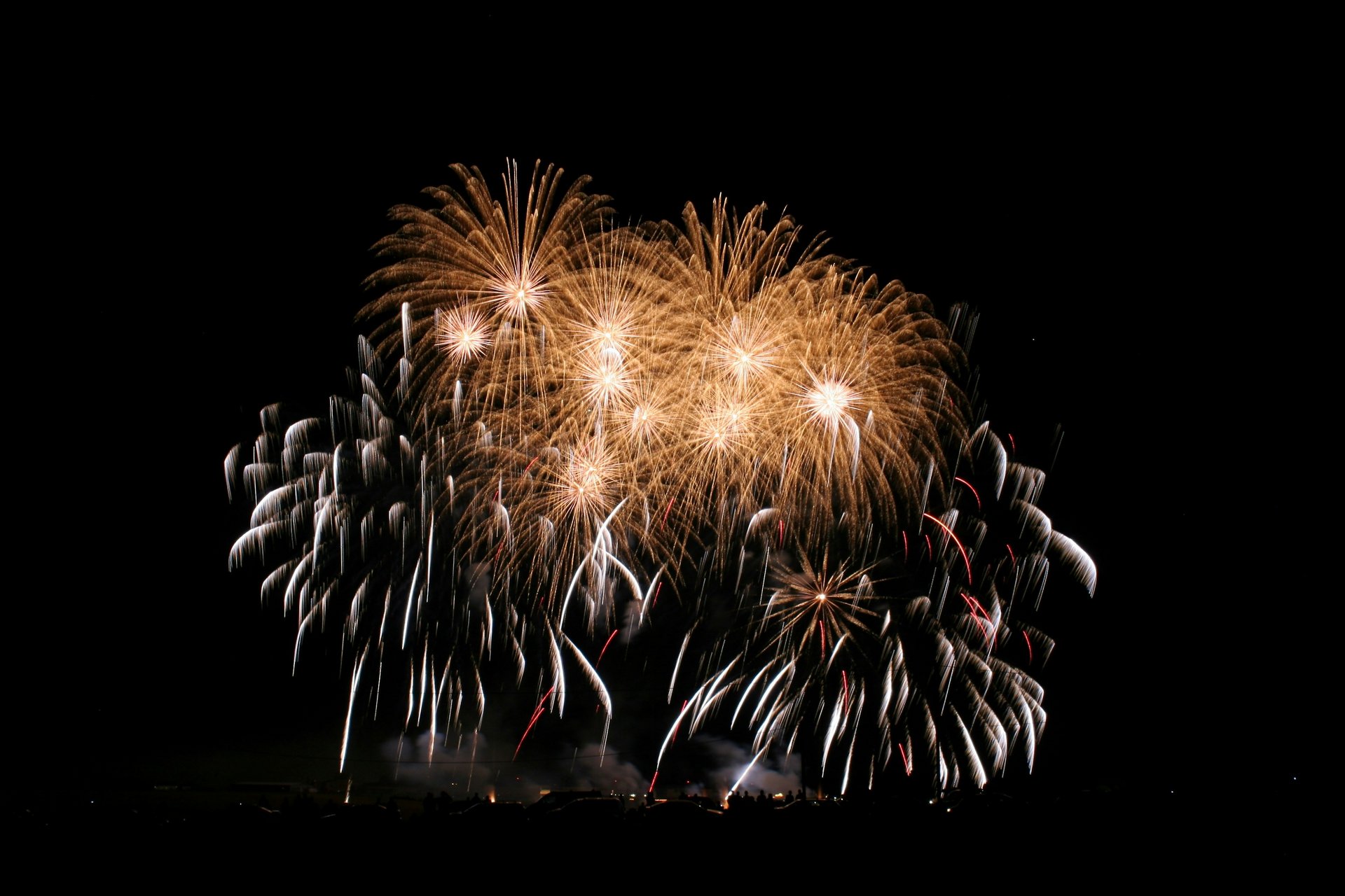 Goldene Feuerwerkskörper erhellen den Nachthimmel während einer Feier