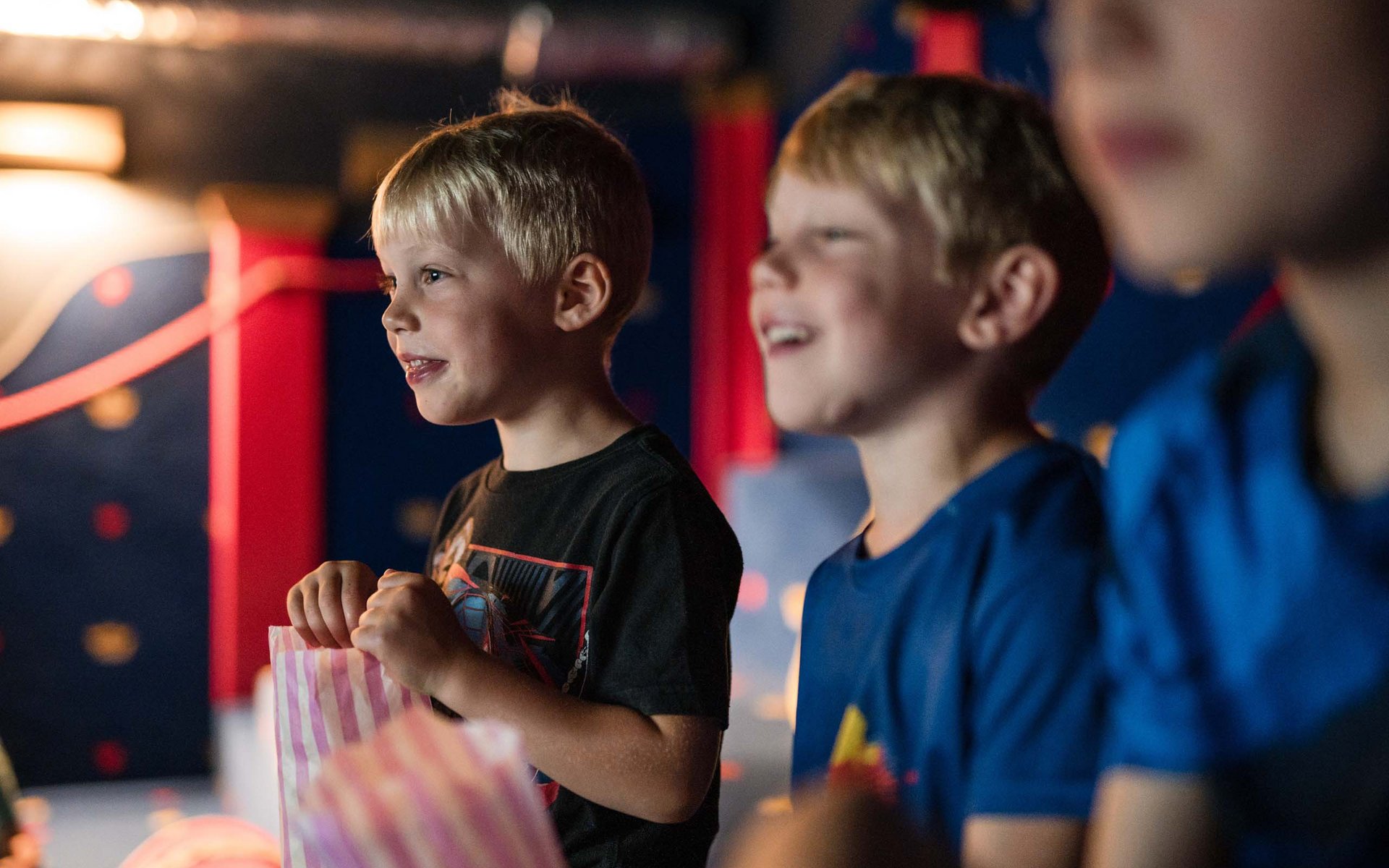 Kinder beim Film schauen mit Popcorntüten
