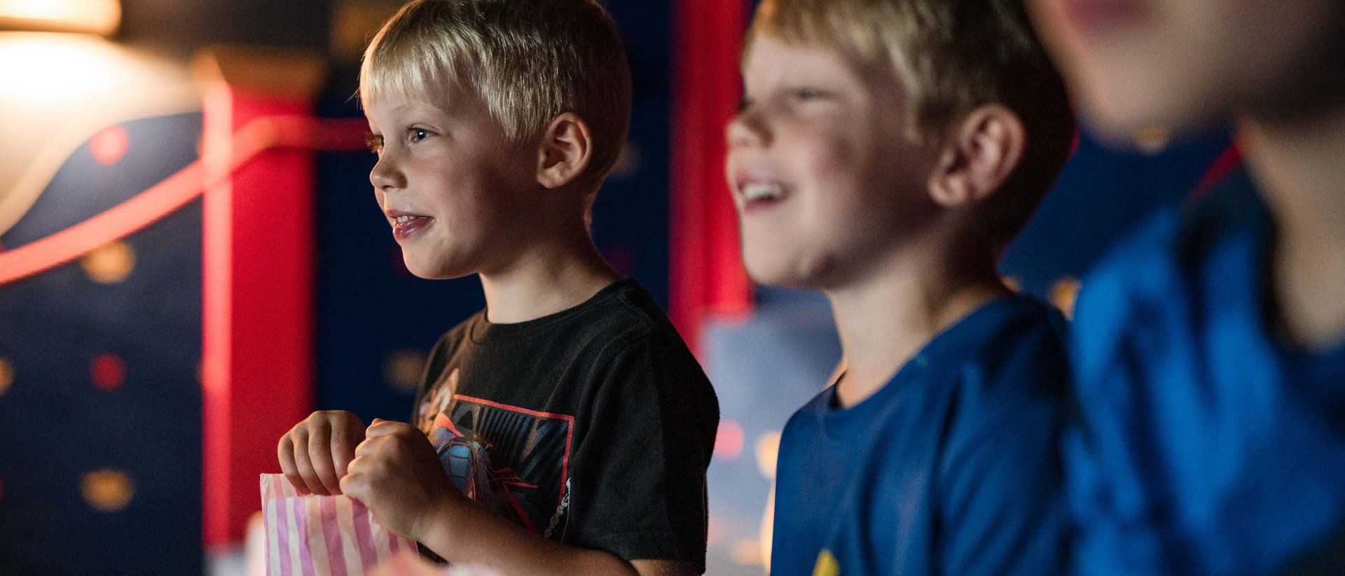Kinder beim Film schauen mit Popcorntüten