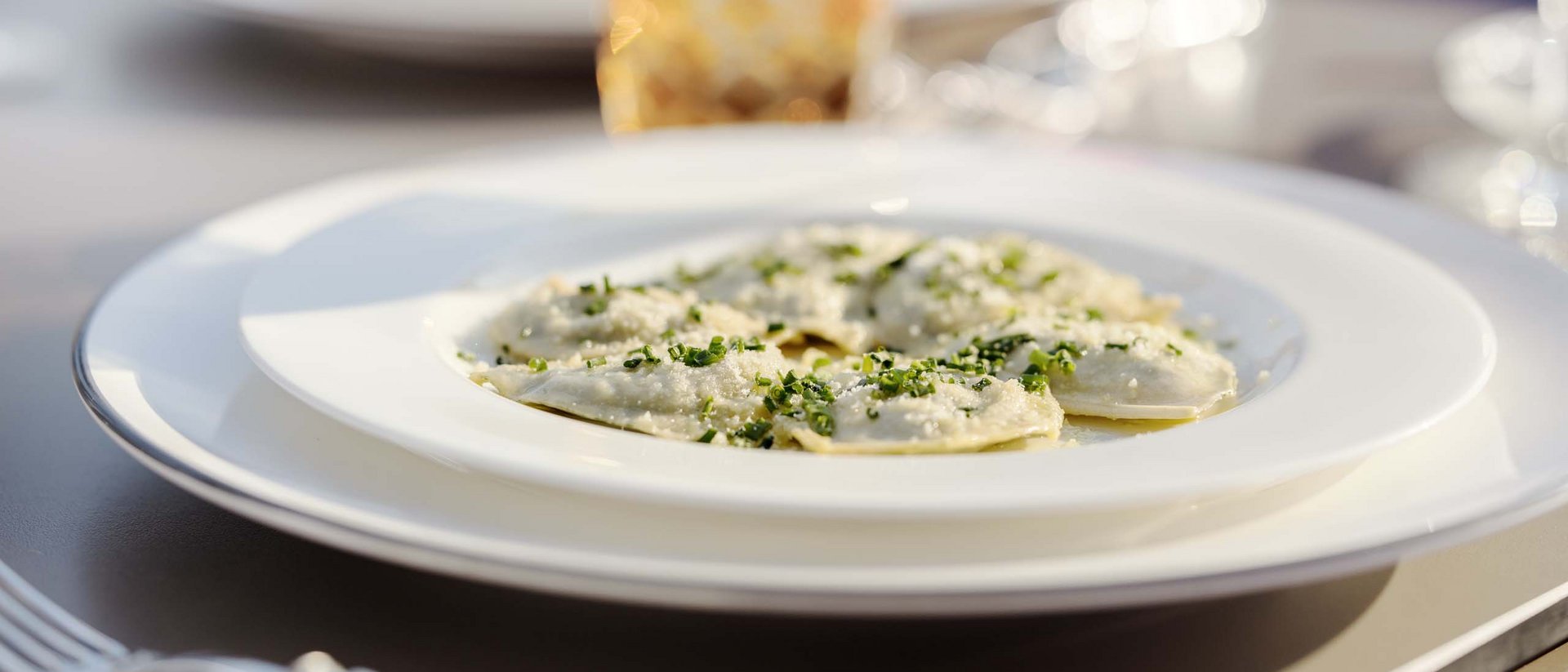 Törggele-Zauber und Herbstgenuss Teller mit gefüllten Ravioli garniert mit Kräutern und Käse