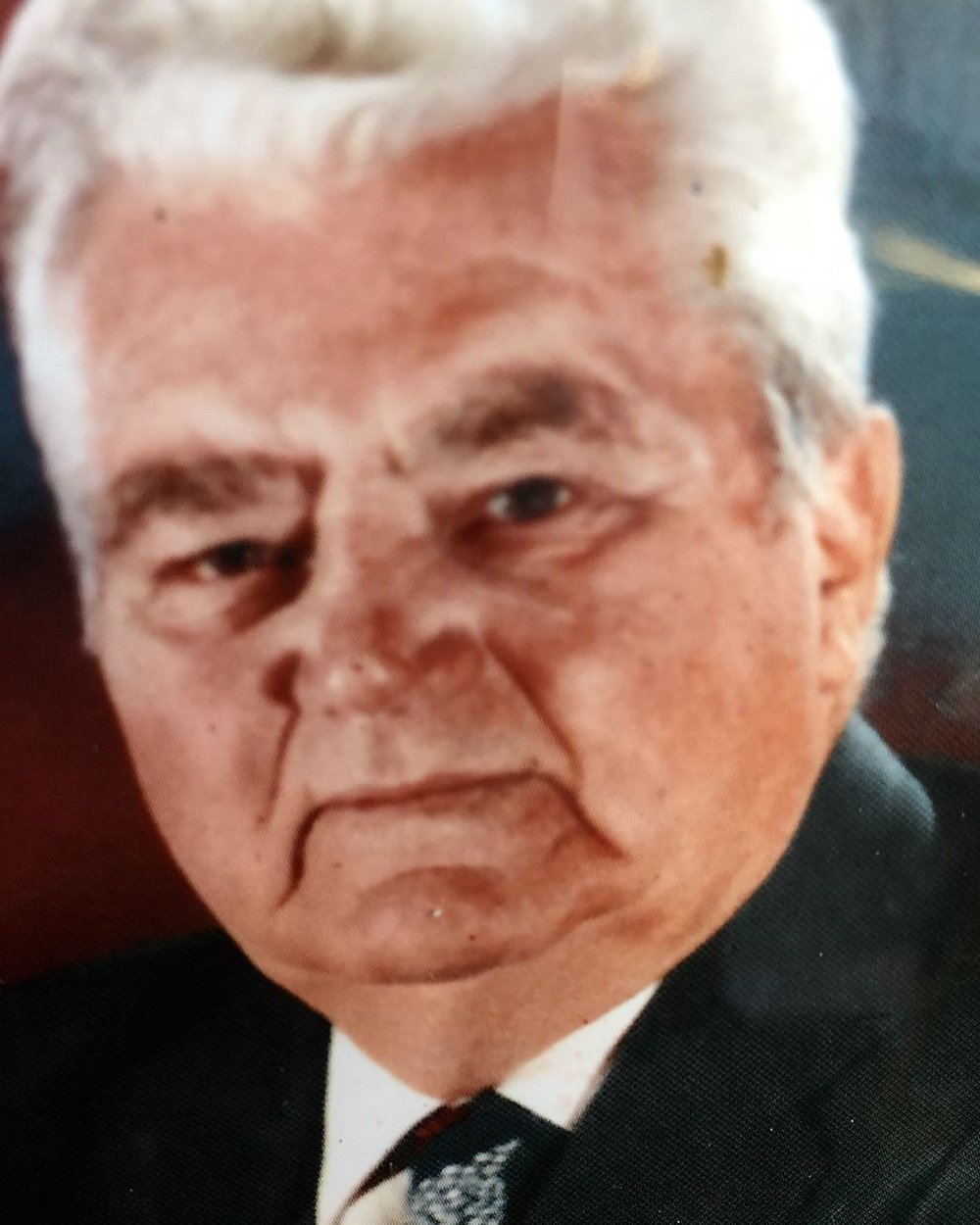 Primo piano di un uomo anziano con capelli bianchi in abito