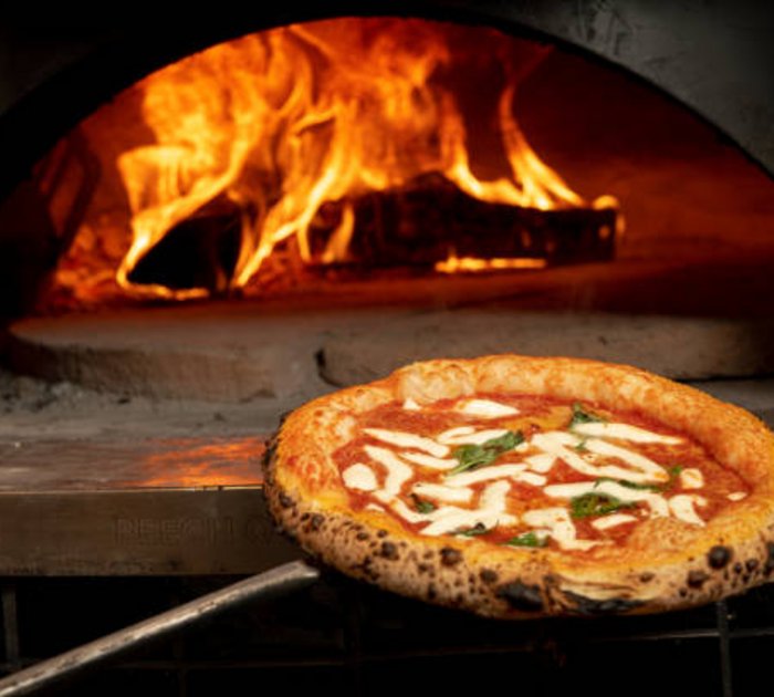 Pizza baking in a traditional wood-fired oven